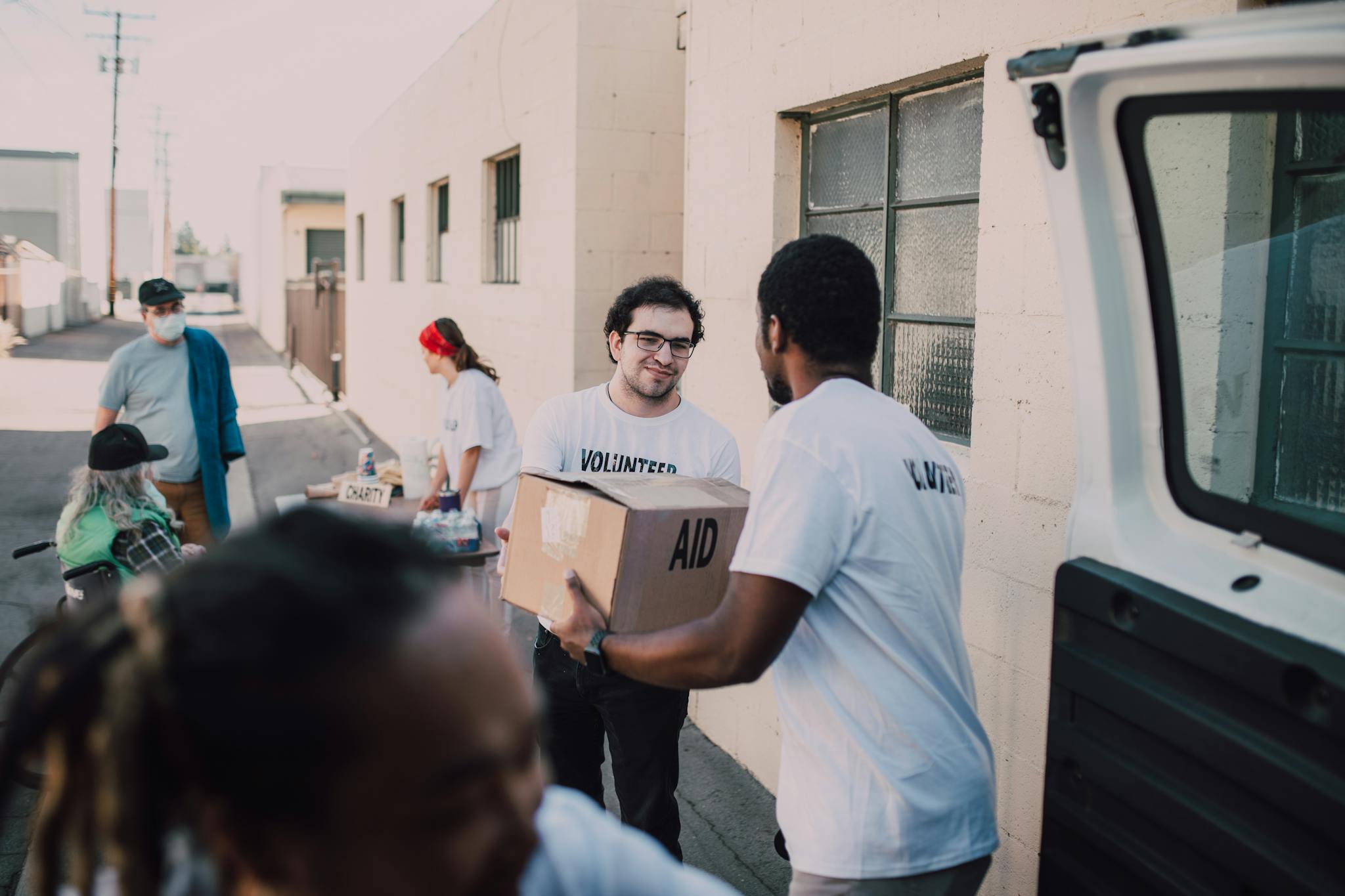 Group of volunteers handing out aid boxes to support community donations.